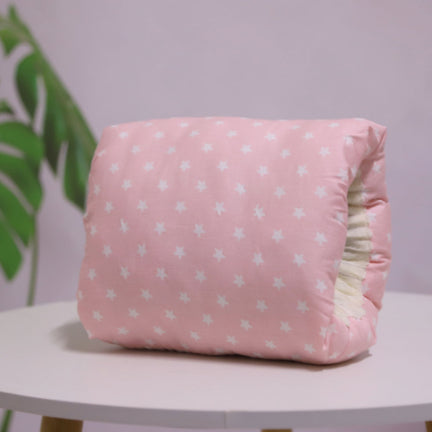 Pink cotton nursing arm pillow with white star pattern, featuring a soft, cushioned design for infant breastfeeding.