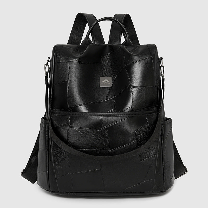 Black leather-look backpack with a minimalist patchwork design, dual straps, and metallic logo plate.