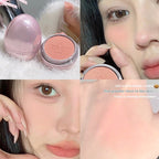 Egg-shaped pink compact with a matte peach face powder featuring an angry face engraving; shown on skin.