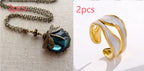 A dragonfly pendant necklace and an open, gold-tone titanium steel ring with wavy white enamel detailing.