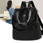 Minimalist black leather patchwork backpack with adjustable straps and metal logo detail, also shown in cream.