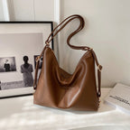 A brown PU leather hobo shoulder bag with a slouchy, vintage-inspired design and gold-tone hardware.