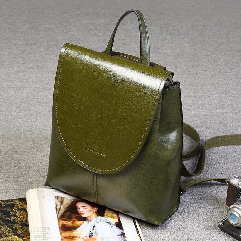 Olive green genuine leather retro-style women's backpack with a top handle, flap closure, and adjustable straps.