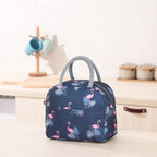 Navy blue thermal lunch bag with pink flamingo and tropical leaf print, grey fabric handles, and zipper closure.