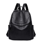 Black soft leather backpack with a flap top, front kangaroo logo, side pockets, and adjustable shoulder straps.
