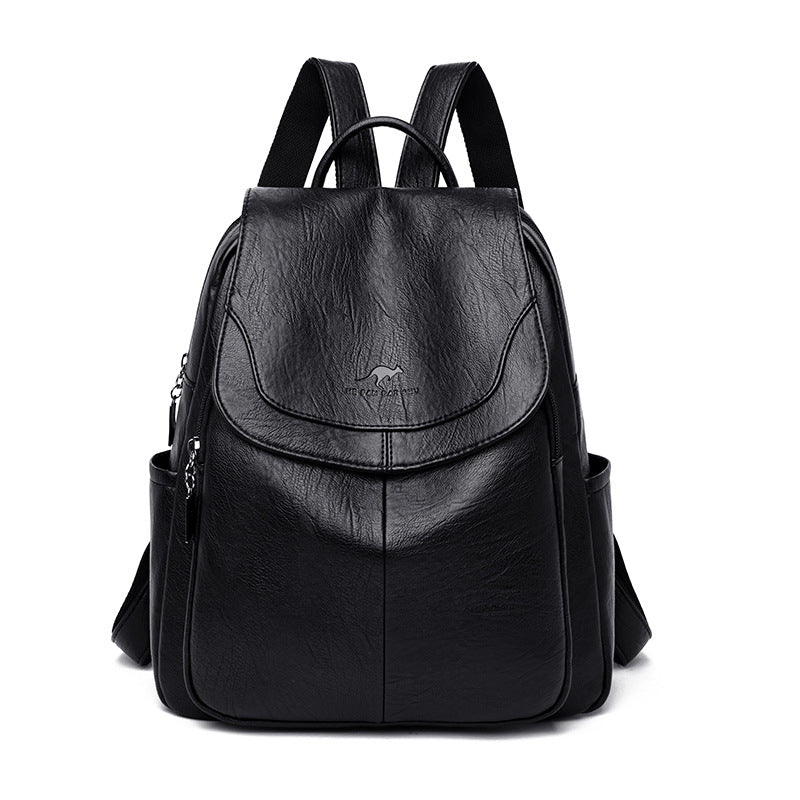 Black soft leather backpack with a flap top, front kangaroo logo, side pockets, and adjustable shoulder straps.