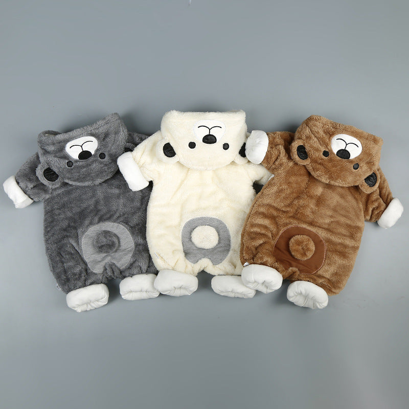 Three plush, fleece baby onesies in gray, cream, and brown, featuring bear hoods and cute belly patches.
