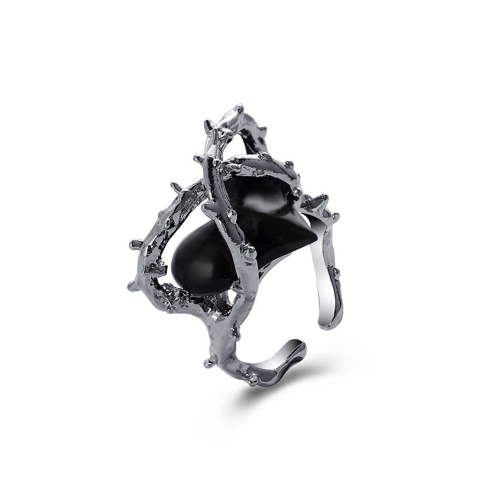 Silver-toned hip hop ring featuring a textured, thorny metal branch design framing a smooth, glossy black center stone.