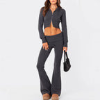 Charcoal grey knit two-piece set featuring a cropped zip-up hooded jacket and low-rise flared pants.