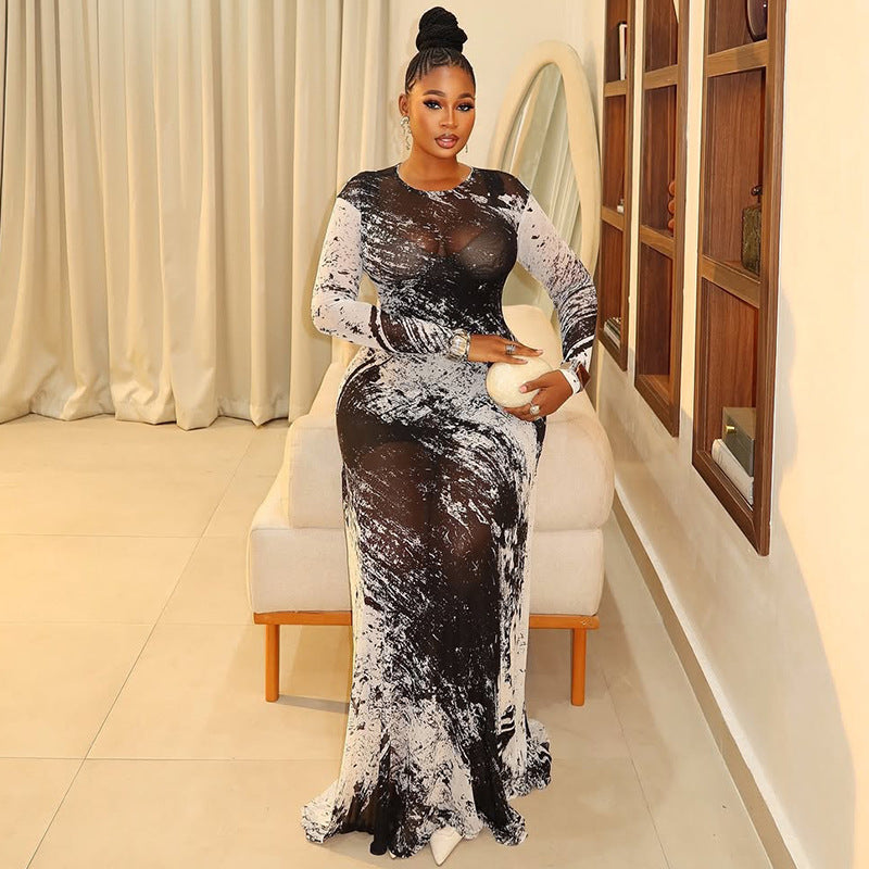 Woman wearing a long-sleeve, black and white marble-print mesh maxi dress with a fitted, straight-tube silhouette.