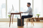 Man in office with feet on under-desk foot warmer
